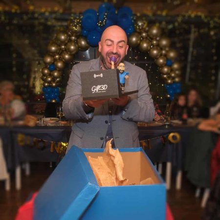 Uomo con barba che apre una scatola regalo con figurine 3D di Gift3D.